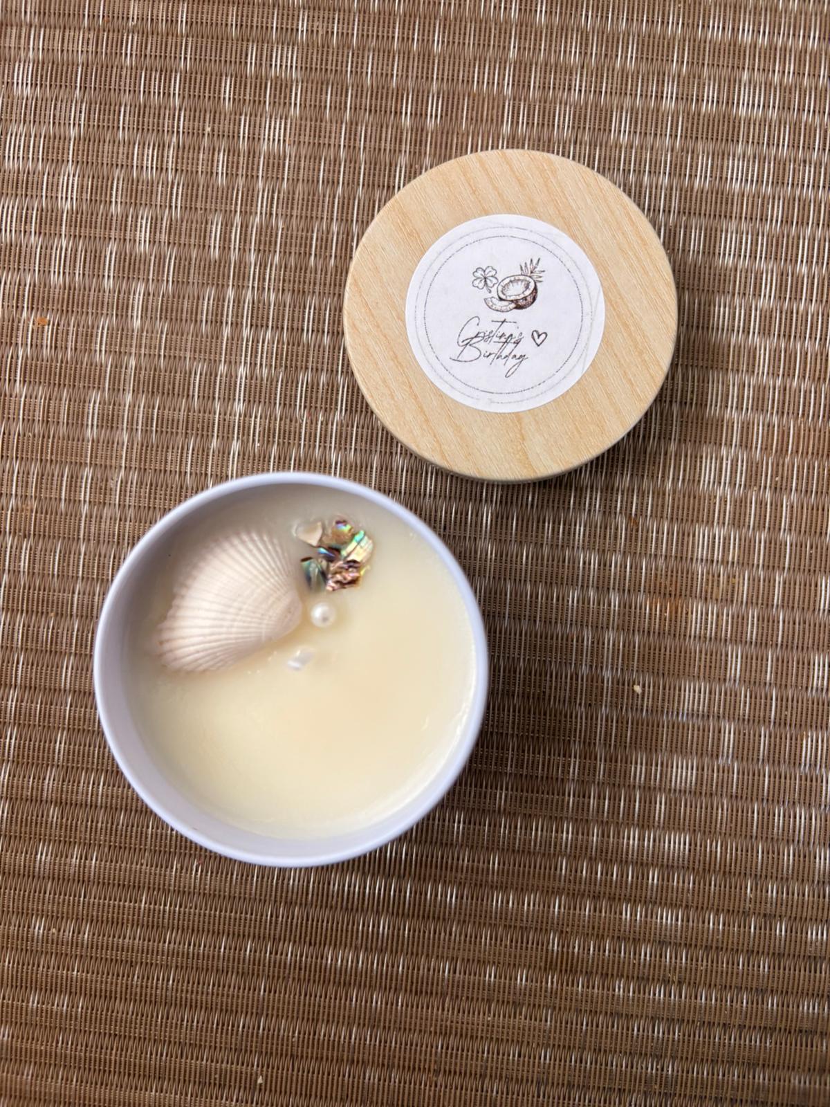Vela artesanal vertida a mano con concha de mar y perlas, con tapa de madera personalizada con el nombre del evento